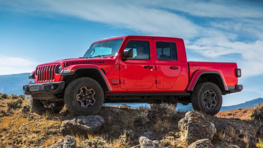 Firecracker Red 2023 Jeep Gladiator pickup truck parked by some rocks