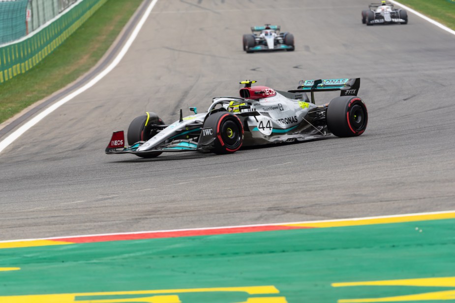 This is Lewis Hamilton taking a corner and suffering from porpoises during a Formula 1 race, two other cars visible in the background.
