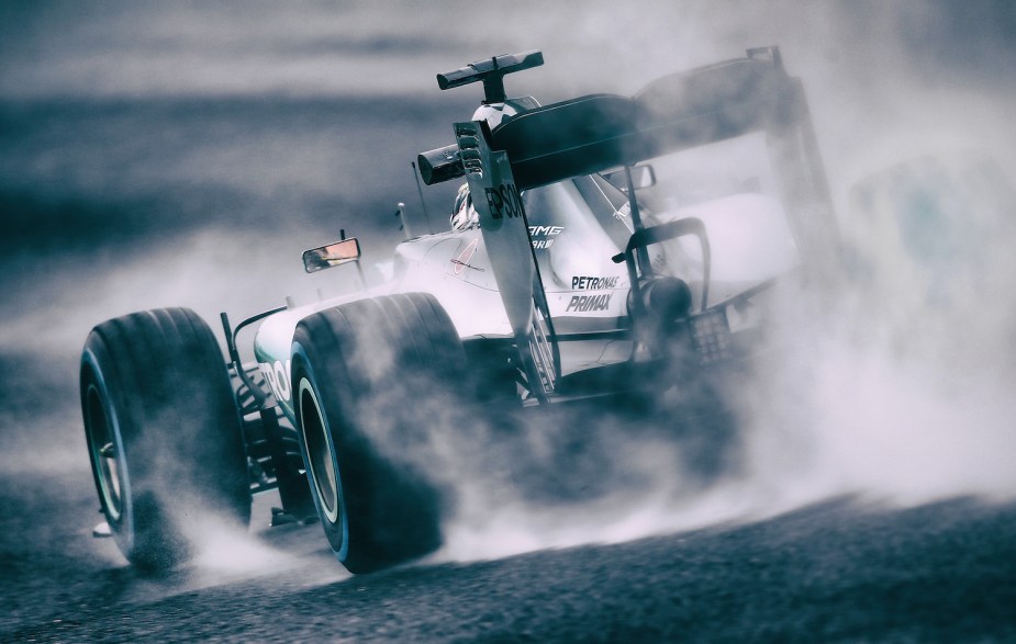 Rearview of a Formula 1 car surrounded by smoke as the driver completes a burnout after winning a race.