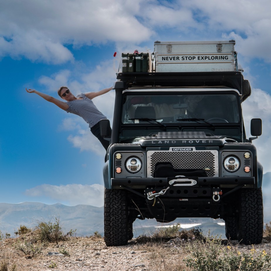 Photo of a Land Rover Defender SUV outfitted with a winch, mountains visible in the background.