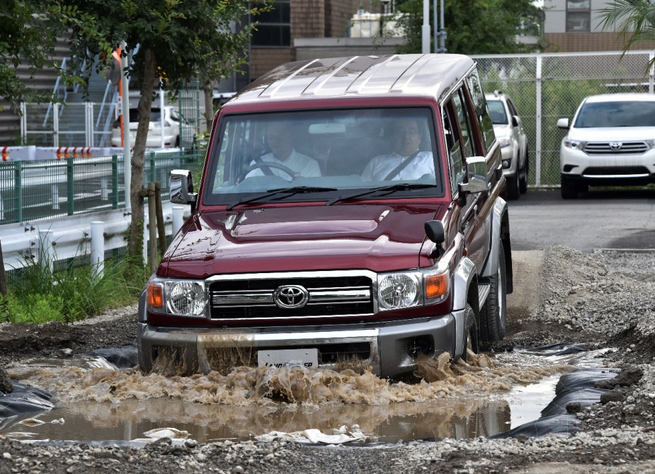A red Toyota LandCruiser 70 SUV shows off how it can ford water.