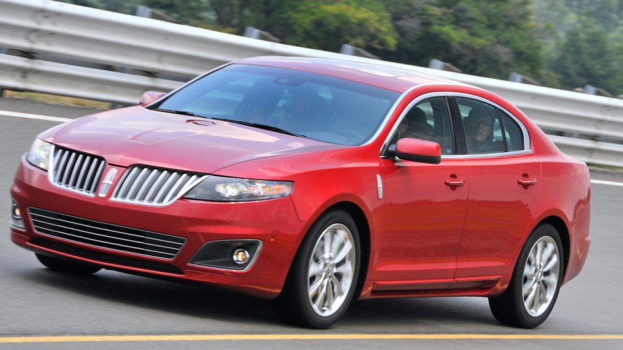 A red 2010 Lincoln MKS is driving on a test track.