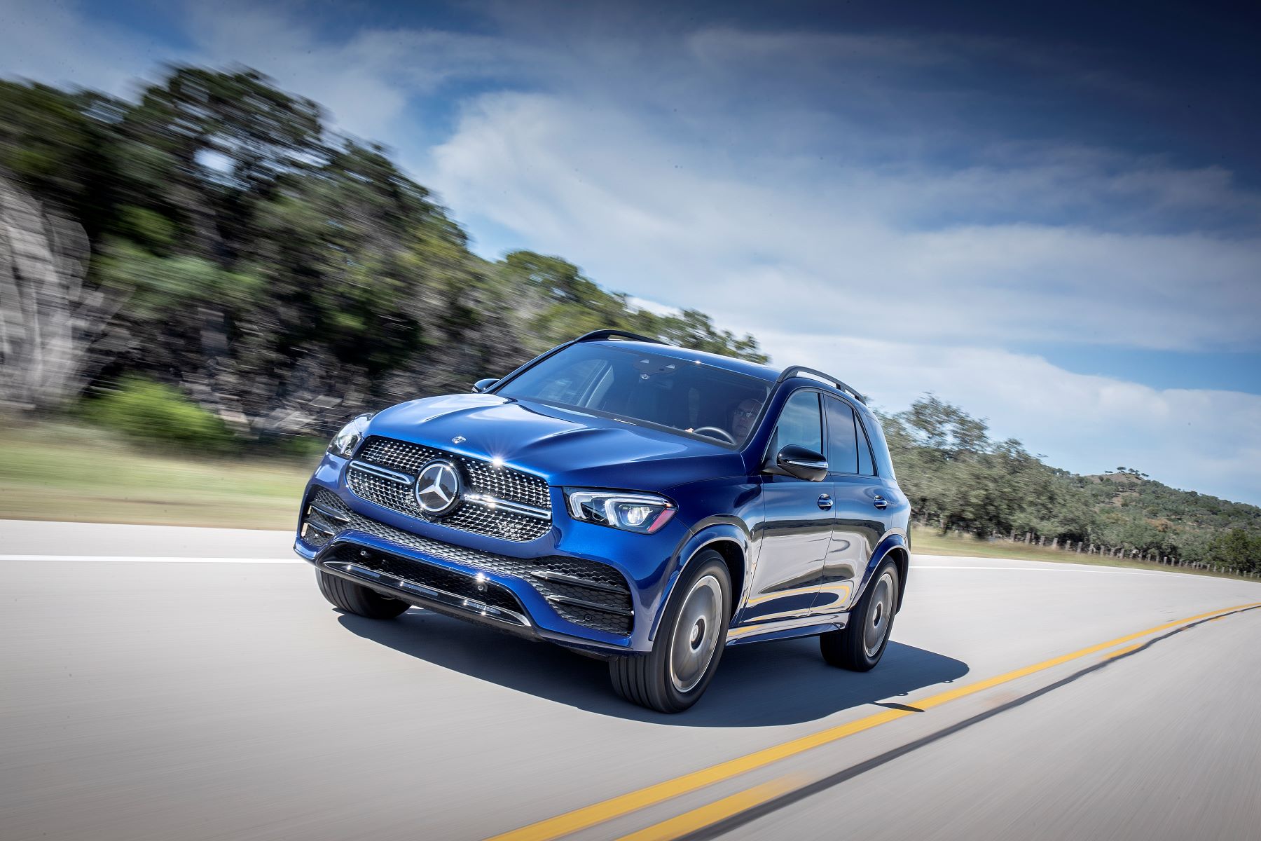 A blue Mercedes-Benz GLE 350 4MATIC midsize luxury SUV model driving down a highway