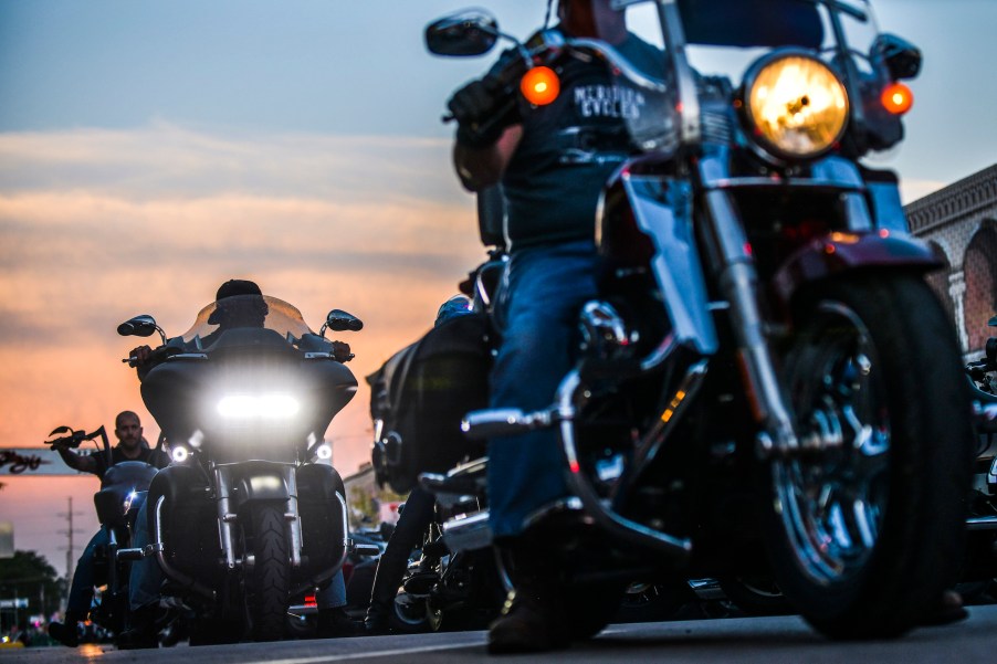 People sharing the road with motorcycles as they drive down the road.
