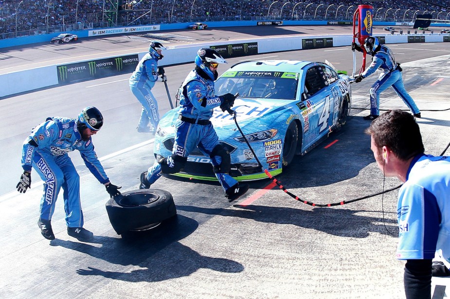 The #4 car competes a pit stop in pit lane during a NASCAR race.