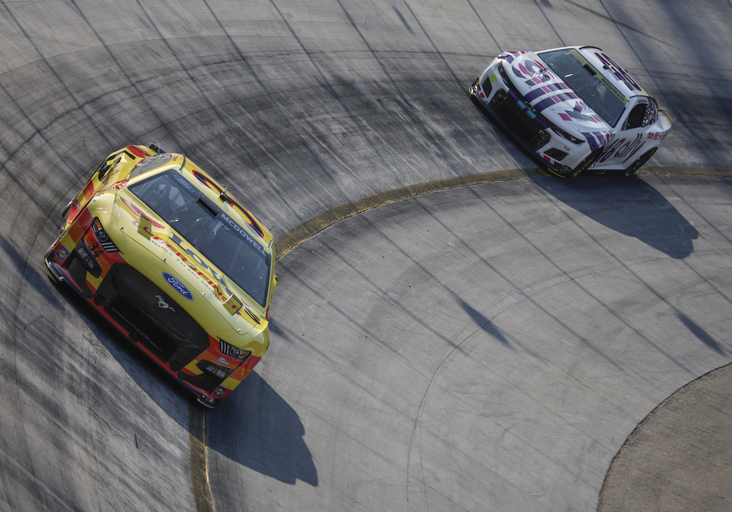 Two NASCAR Cup Cars completing practice laps at Bristol Motor Speedway before a race.