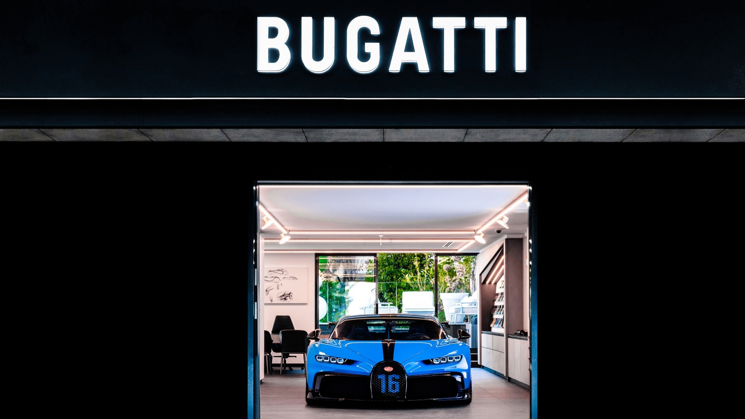 The new Bugatti logo on a building with the Bugatti Chiron Pur Sport under it