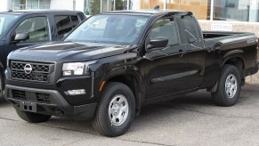 A 2022 Nissan Frontier S sits in a parking lot with black paint.