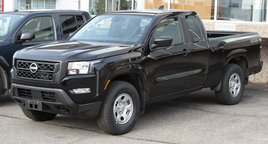 A 2022 Nissan Frontier S sits in a parking lot with black paint.