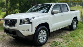 A white 2022 Nissan Frontier S sits in a field.