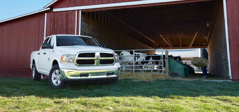  A white ram 1500 classic next to a barn 