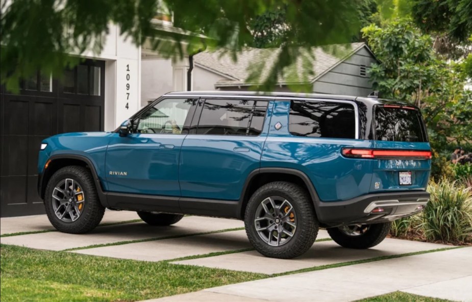 Rear angle view of blue 2022 Rivian R1S, cheaper electric luxury SUV alternative to Tesla Model X