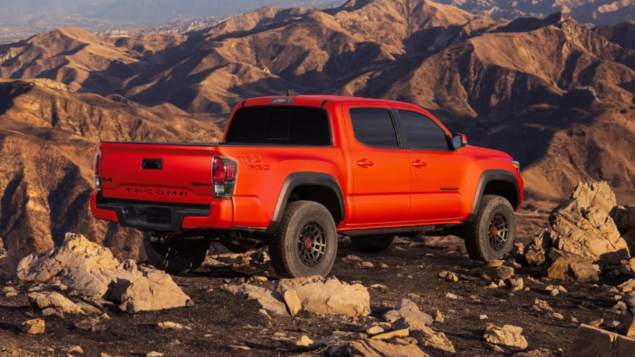 Rear angle view of new orange 2023 Toyota Tacoma midsize pickup truck, highlighting how much a fully loaded one costs