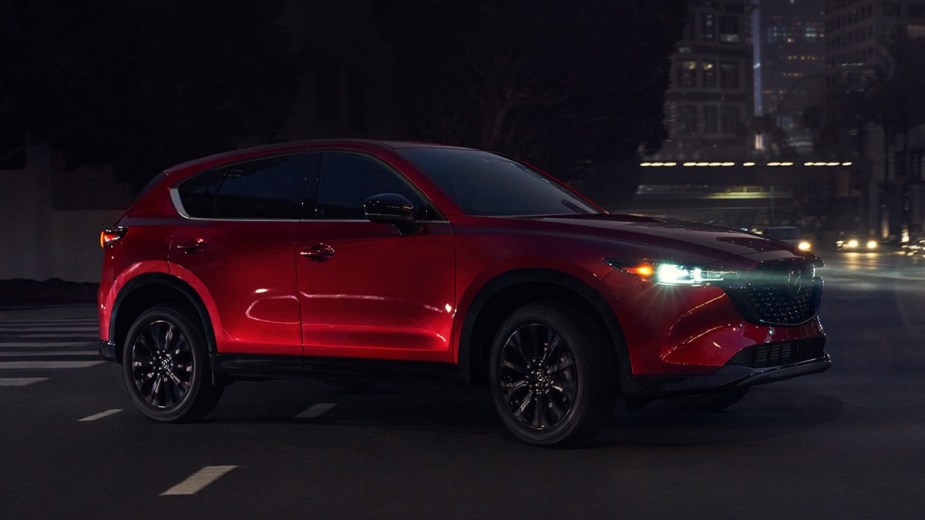 Red 2023 Mazda CX-5 Crossover SUV Driving On City Road At Night