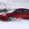 Red 2023 Subaru Impreza, the only new car with all-wheel drive costing under $20,000, driving in snow