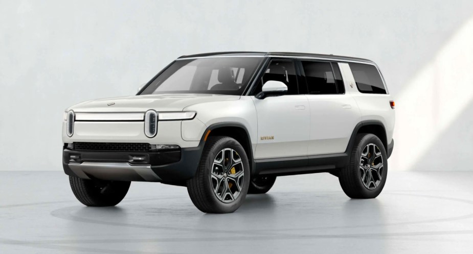 A white Rivian R1S electric SUV is parked.