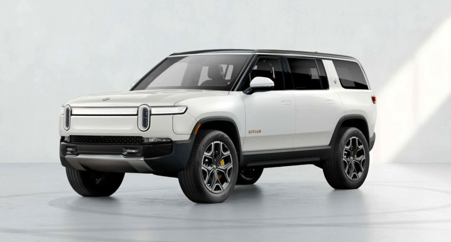 A white Rivian R1S electric SUV is parked. 