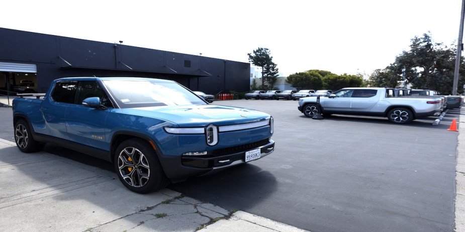 A Rivian R1T parked outside a building. 