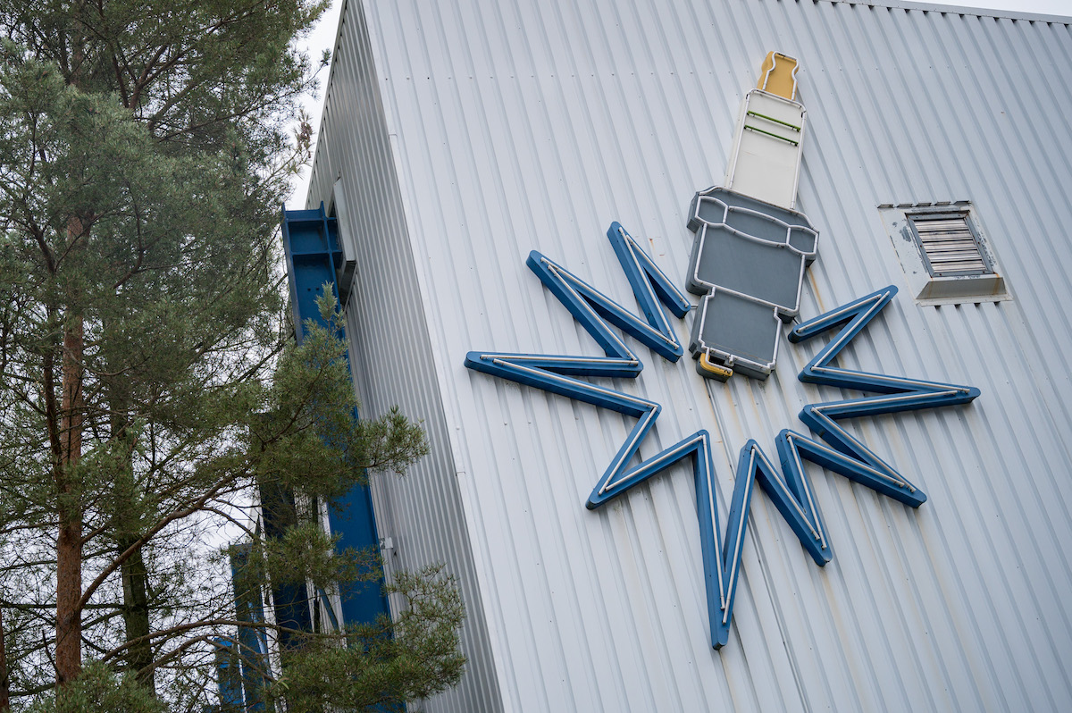 A depiction of spark plugs on the side of a white building. 