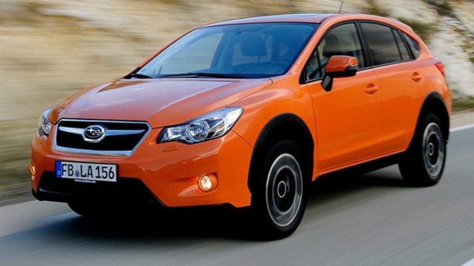 Orange Subaru XV Driving on a Road