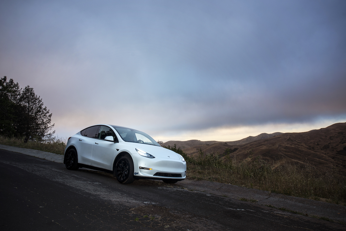 A white Tesla with full-self driving in a desert area.