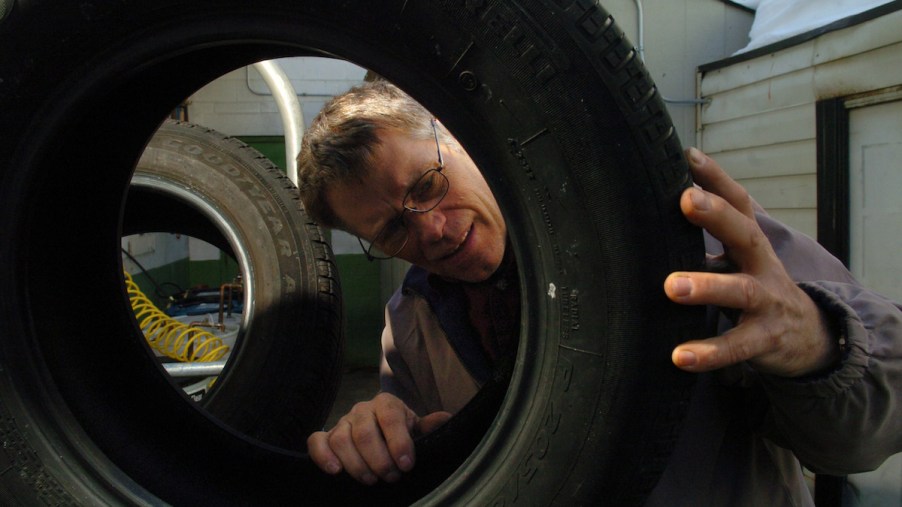 A person looking at the tire's sidewall.