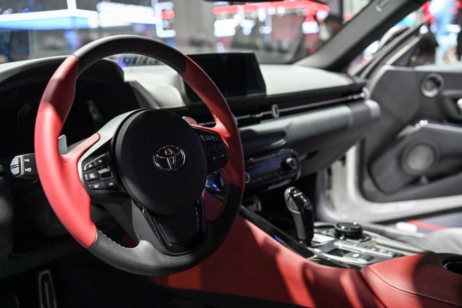 A red and black steering wheel in a Toyota GR Supra