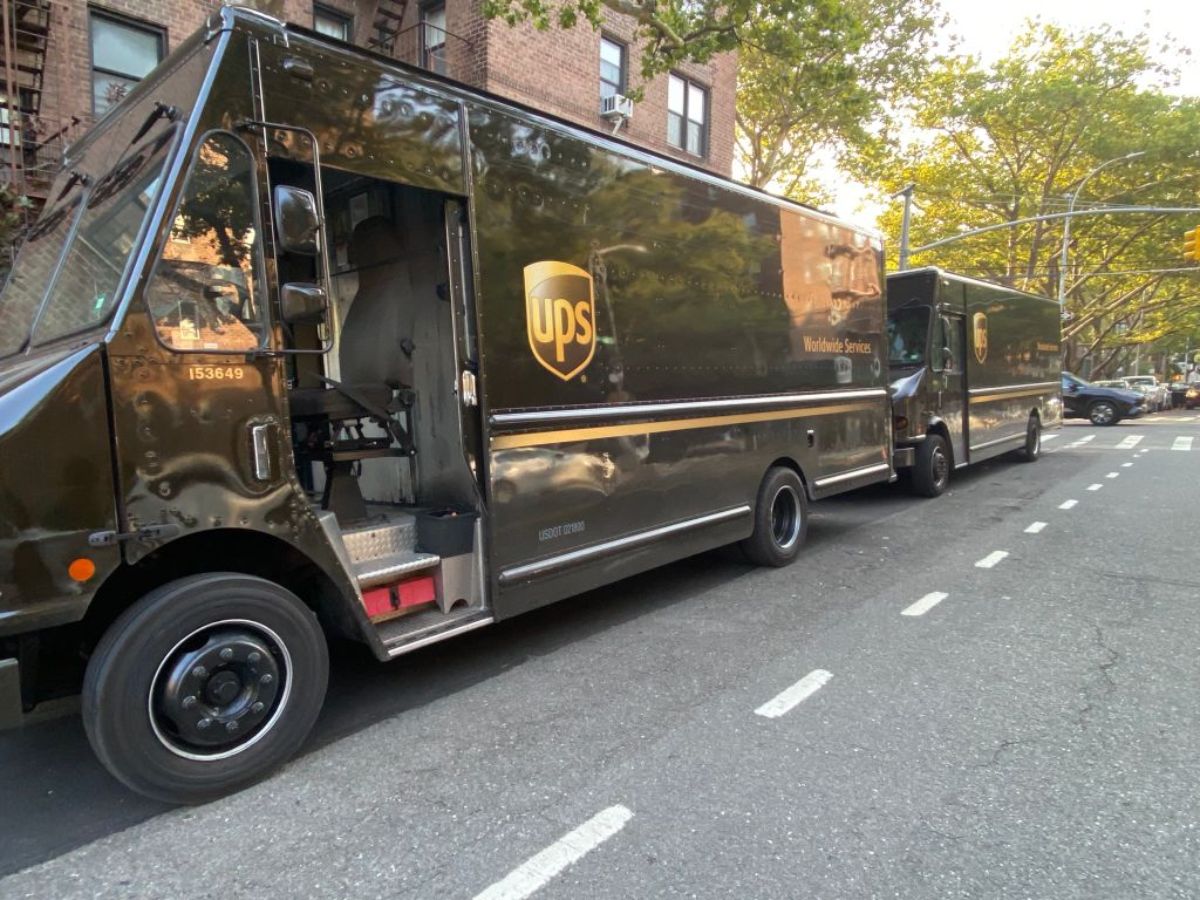 Two UPS trucks parked on the side of the road.
