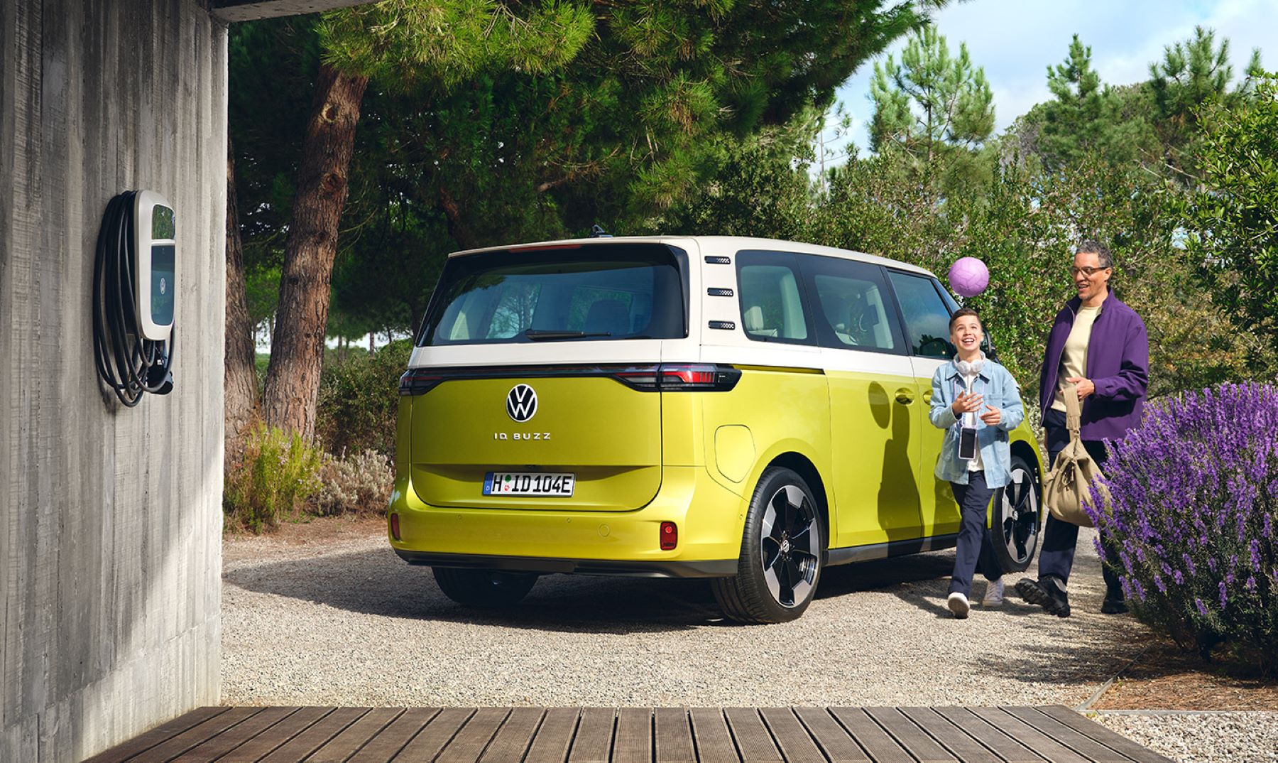 A yellow Volkswagen ID. Buzz all-electric microbus with an at-home EV charger