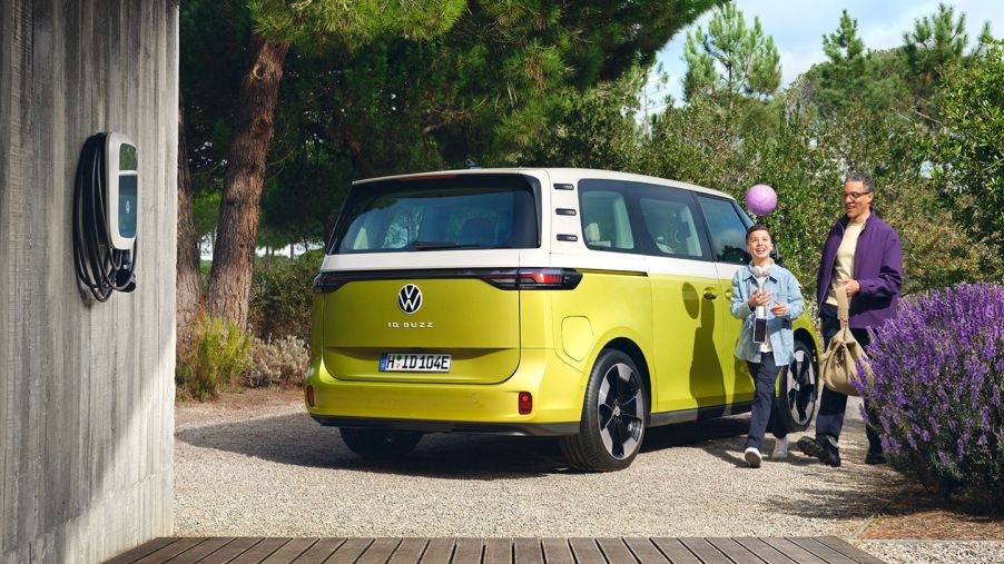 A yellow Volkswagen ID. Buzz all-electric microbus with an at-home EV charger
