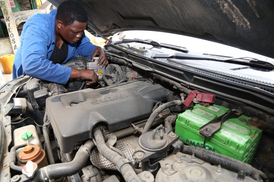 A person performing a repair on a vehicle. 
