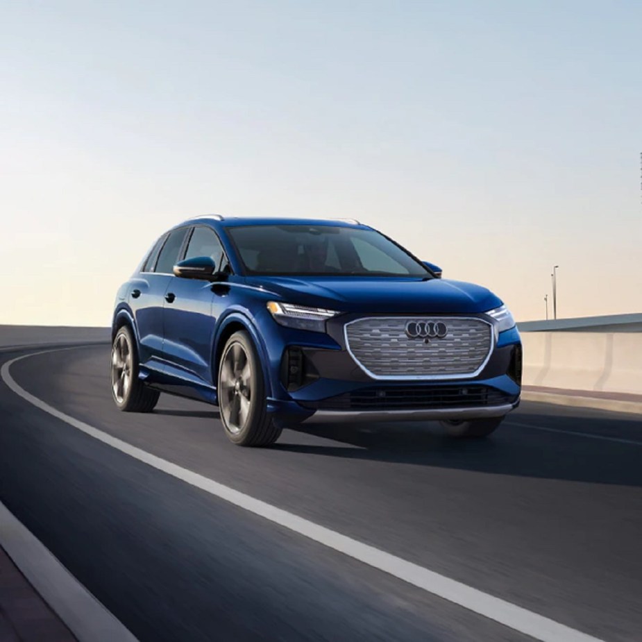 A blue 2022 Audi e-Tron driving down a winding road. 