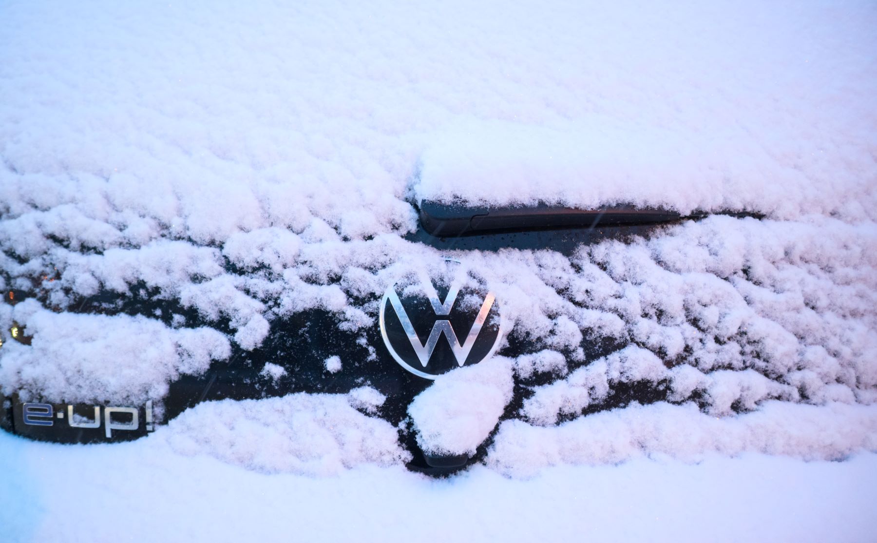 A Volkswagen e-Up! electric vehicle (EV) covered in snow during the winter in Lower Saxony, Laatzen