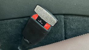 A picture of a seatbelt alarm stopper being used in place of a seatbelt.