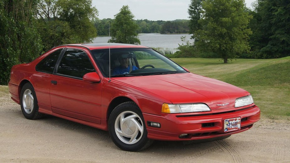 Red 1989 Ford Thunderbird parked by a lake