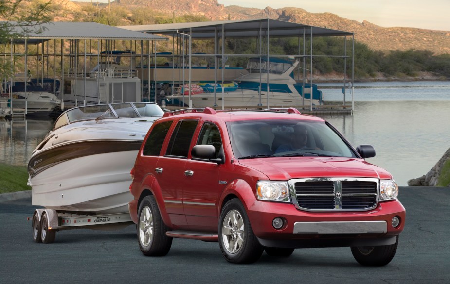 Promo photo of Dodge's 2009 hybrid Durango SUV attached to a large boat trailer, a marina visible in the background.