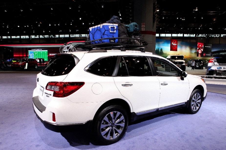 A white 2017 Subaru Outback SUV is on display at an auto show.
