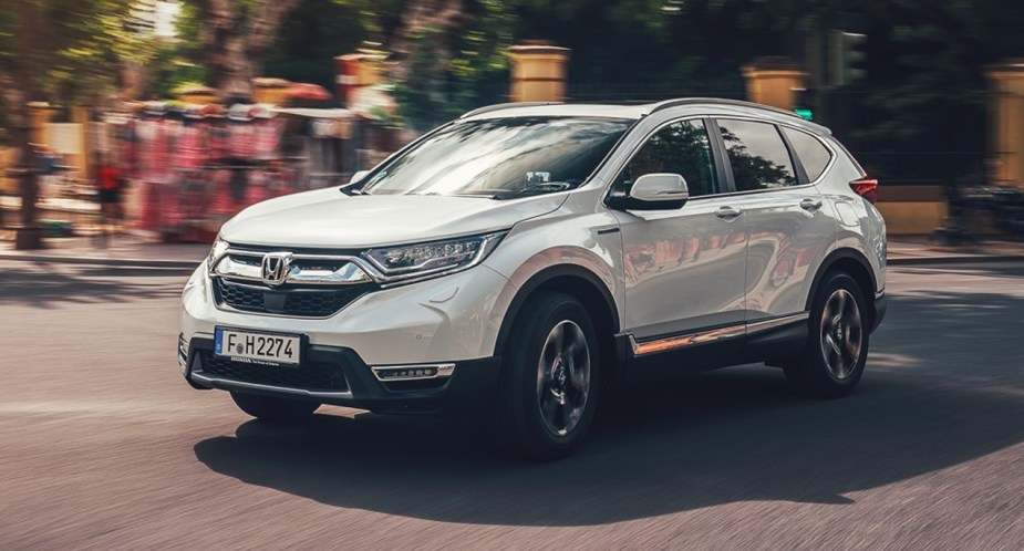 A white 2019 Honda CR-V small SUV is driving on the road. 