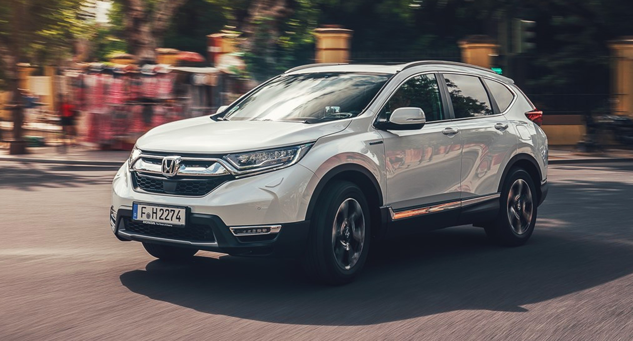 A white 2019 Honda CR-V small SUV is driving on the road.