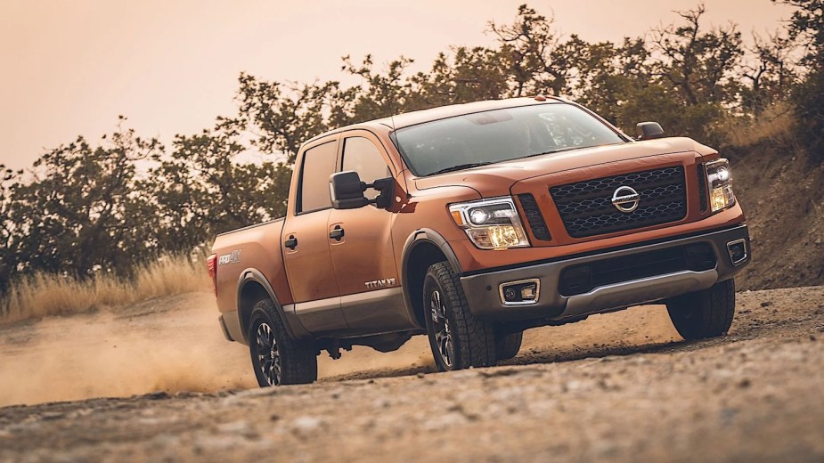 Promo photo of a the 2019 Nissan Titan, a reliable used pickup truck, driving on a dirt road.