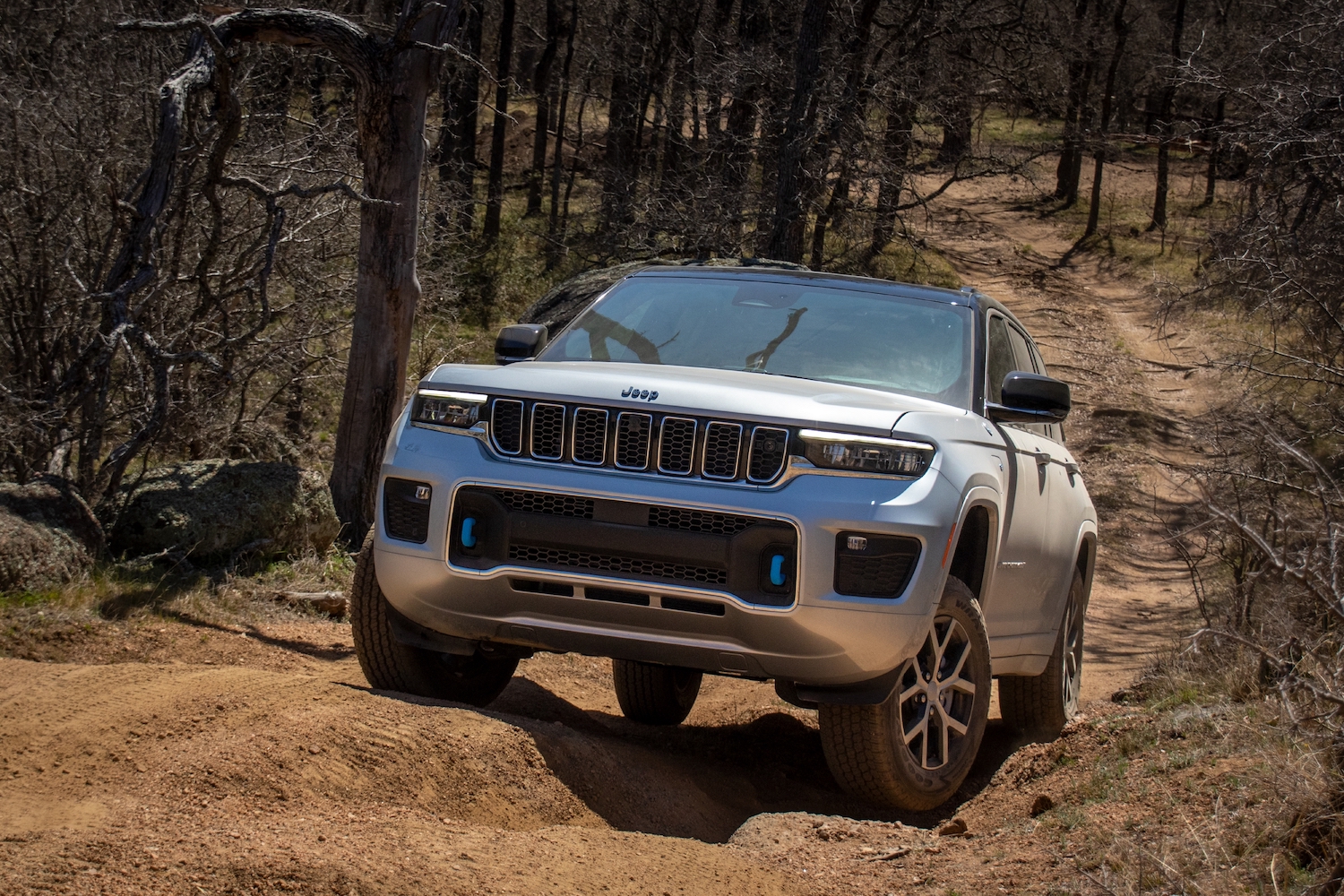Jeep Grand Cherokee 4xe hybrid SUV climbing a steep off-road trail.