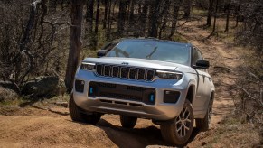 Jeep Grand Cherokee 4xe hybrid SUV climbing a steep off-road trail.