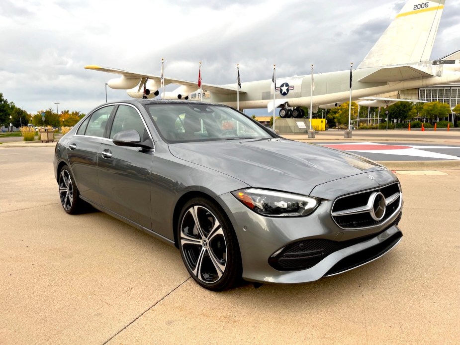A front view of the 2022 Mercedes-Benz C-Class next to a plane