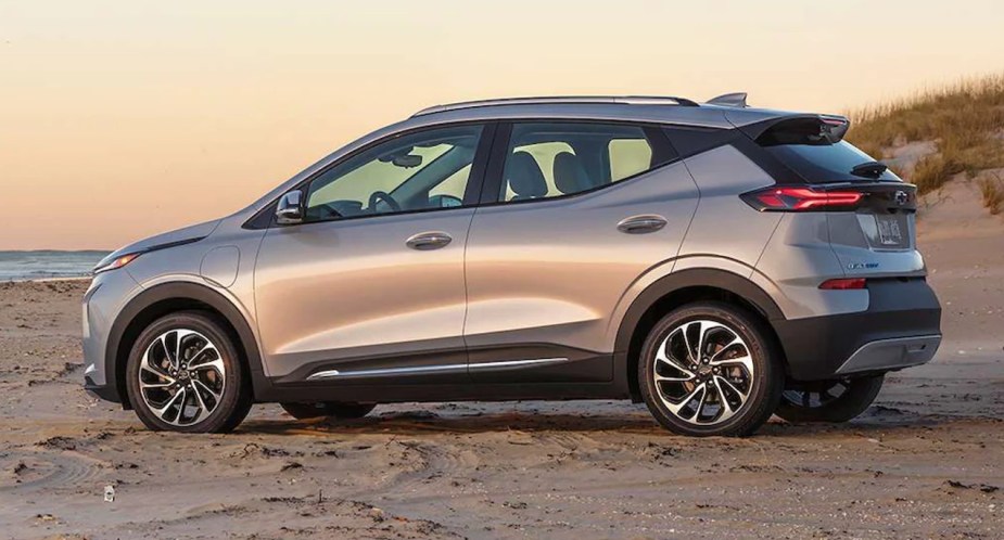 A 2023 Chevy Bolt EUV subcompact electric SUV is parked on a beach. 