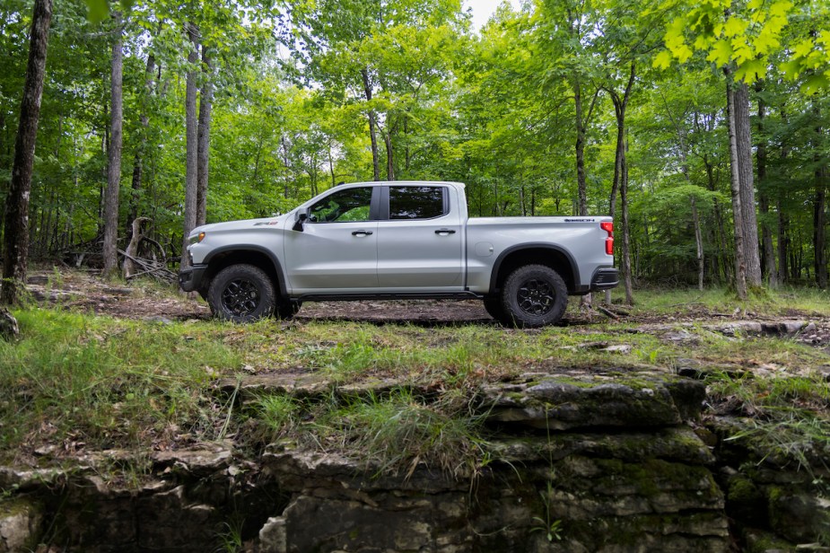 A 2023 Chevy Silverado 1500 pickup truck sits in a wooded area.