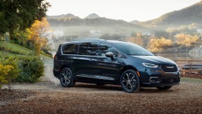 A dark 2023 Chrysler Pacifica PHEV parked in a fall scene.