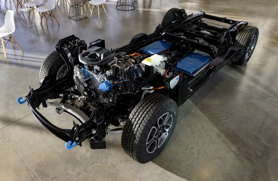 A Jeep Grand Cherokee 4xe plug-in hybrid SUV stripped down to its chassis for display.