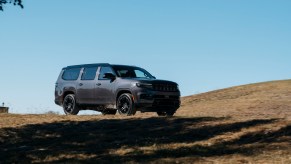 The 2023 Jeep Wagoneer blacked-out Carbide Edition with an I6 Hurricane Edition driving along a track, the blue sky visible in the background.