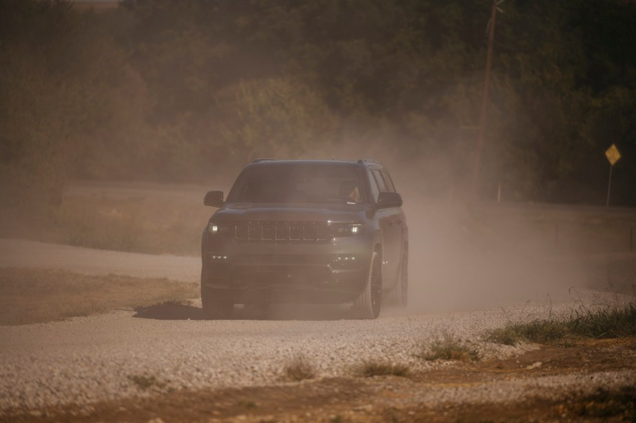 Hurricane I6-powered 2023 Jeep Wagoneer Series II full-size SUV driving on a dirt road, dust visible in the background.