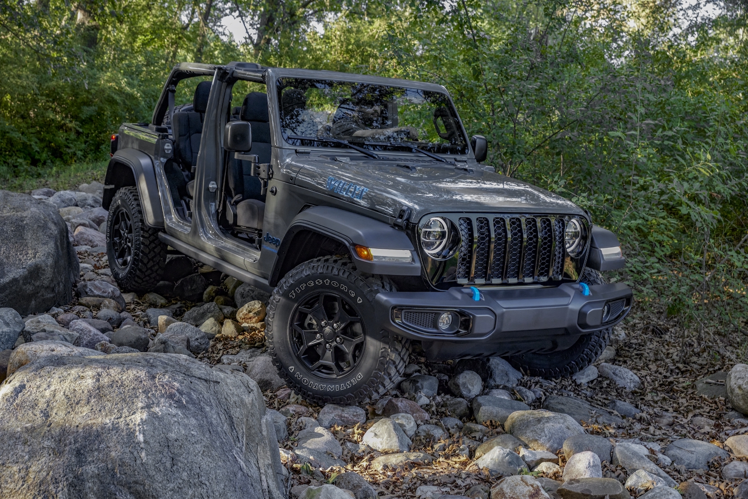 Gray entry-level Jeep Wrangler 4xe parked in the middle of a rocky off-road trail.